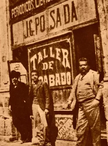 Historic photograph of José Guadalupe Posada standing outside his print workshop, Taller de Grabado, in Mexico City.